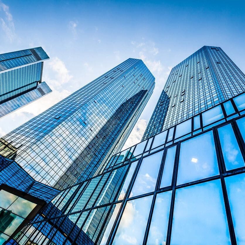 Glass skyscrapers towering under blue sky