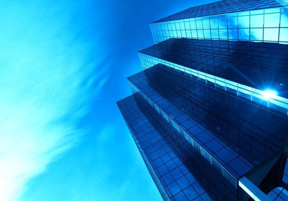Low-angle blue glass skyscraper with sky reflection